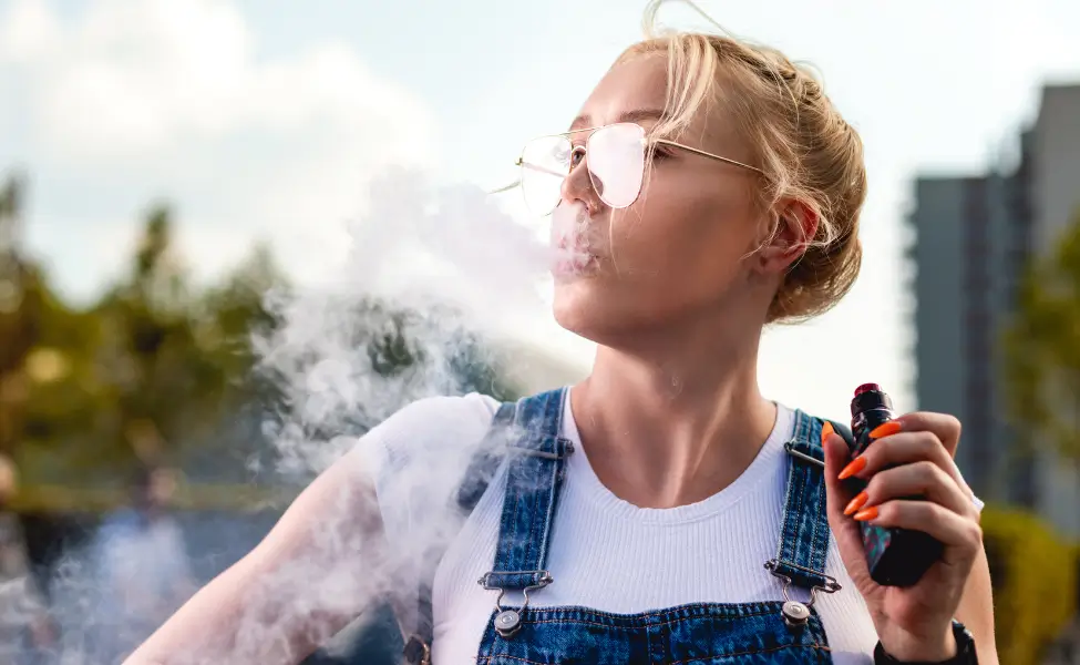 Young Woman Holding Vape With Smoke Outdoors Young Woman Holding Vape With Smoke Outdoors